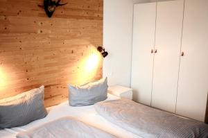 a bedroom with a wooden accent wall and a bed at Ferienhaus Nr 47, Kategorie Premium, Feriendorf Hochbergle, Allgäu in Lechbruck
