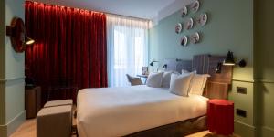 a bedroom with a large bed and a red curtain at Urban Hive Milano in Milan