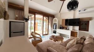 a living room with a couch and a table at Cape Beach Villa Samui in Ban Bang Po