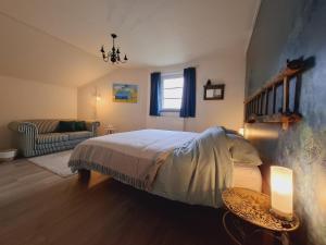a bedroom with a bed and a living room at Gîte Les bergeronnettes in Tavigny