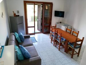 a living room with a couch and a table at A window on the saline beach in Calasetta