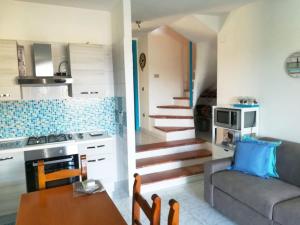 a kitchen and a living room with a couch and a table at A window on the saline beach in Calasetta