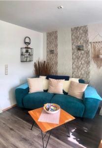 Alt ReddevitzにあるFerienwohnung nordisch Kühlのリビングルーム(青いソファ、テーブル付)