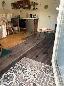 Alt ReddevitzにあるFerienwohnung nordisch Kühlのウッドフロアのリビングルーム、キッチンが備わります。