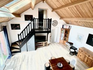 a living room with a spiral staircase and a table at Le Lodge Champenois in Épernay