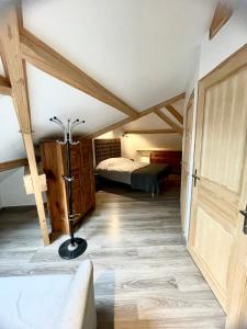 a bedroom with a bed in a room with wooden ceilings at Le Lodge Champenois in Épernay