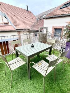 a picnic table and chairs on the grass at Le Lodge Champenois in Épernay