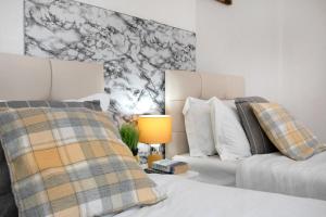 ein Schlafzimmer mit zwei Betten und einem Tisch mit Lampe in der Unterkunft Tsalach Short Lets in Nottingham