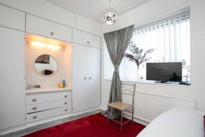 ein Schlafzimmer mit einem Bett, einem Fernseher und einem Fenster in der Unterkunft Tsalach Short Lets in Nottingham