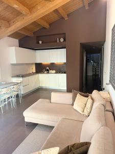 un salon avec un canapé blanc et une cuisine dans l'établissement Elegante torretta in centro, à Faenza