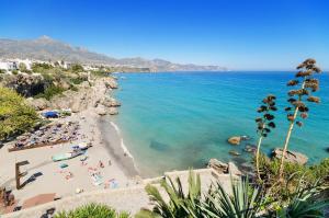 widok na plażę z ludźmi w wodzie w obiekcie Carabeo 1-30 w mieście Nerja