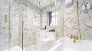 a bathroom with a tub and a toilet and a shower at New Modern Stylish Villa Near City Centre Birmingham, with outdoor Hot Tub in Birmingham +22 photos