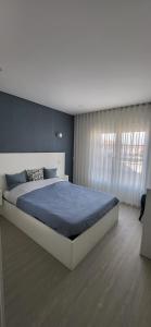 a bedroom with a large bed with a blue blanket at Beach House Altura in Altura