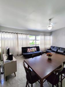 a living room with a table and a couch at 11A - Apto c/2 QUARTOS, Sala e Cozinha completa,1WC, 1 Vaga, Roupa de Cama e VIVO FIBRA in Guarujá