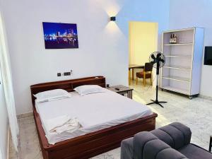 a bedroom with a bed and a chair in a room at Les Résidences Terre Royale in Sokouhoué