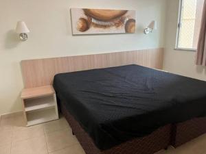 Un dormitorio con una cama negra y un bol en la pared en Thermas do Bosque, en Jeriquara