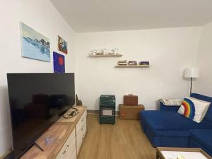 a living room with a blue couch and a flat screen tv at Casa Nico and Vico in Scalea