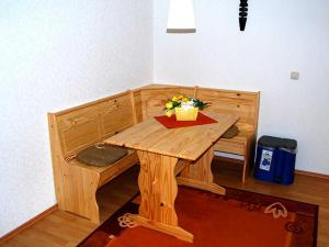 a wooden bench with a table in a room at Ferienwohnungen Haus Mecklenburg in Elmenhorst