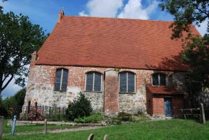 an old brick building with a red roof at Ferienhaus Sonnenschein in Breege in Juliusruh +14 photos