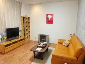 a living room with a couch and a coffee table at Aioi Lodge in Otaru