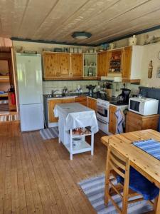 a kitchen with a refrigerator and a table in it at Ånnstugan in Duved