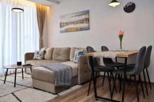 a living room with a couch and a table with chairs at Zeleni vrh A03 in Kopaonik