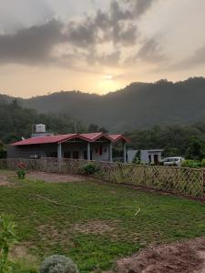 ein Haus mit einem Zaun vor einem Feld in der Unterkunft Kutuumb Morni Hills in Morni + 49 Fotos