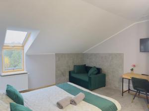 a bedroom with a bed and a green couch at Apartamenty Route 65 in Grabówka