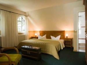 a hotel room with a bed and a suitcase at Hotel Hiddensee Hitthim in Kloster