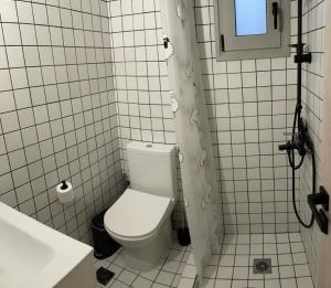a white bathroom with a toilet and a sink at Beachfront Family Home in Levendokhórion