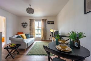 a living room with a table and a couch at Swift Host - 2 Bedrooms - Apartment - Unthank Road - Golden Triangle in Norwich