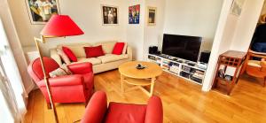 a living room with a couch and red chairs at Spacious apartment 4 people parking, bright in Aix-en-Provence