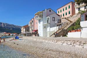 a group of buildings on a beach next to the water at Studio Mihovil in Baška +21 photos