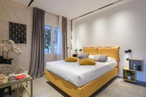 a bedroom with a bed with yellow pillows on it at Malvasiasuites in Bologna