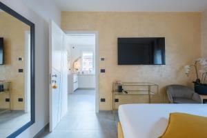 a bedroom with a bed and a television on the wall at Malvasiasuites in Bologna