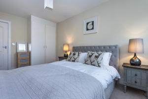 a bedroom with a large white bed and two lamps at Riverside Apartment in London