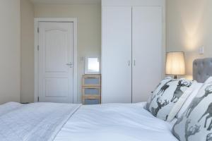 a bedroom with a white bed and a lamp at Riverside Apartment in London