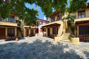 a group of buildings with stairs in a courtyard at Alkifron Hotel in Kala Nera