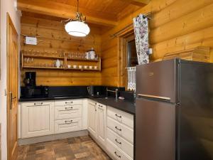 una cucina con frigorifero e pareti in legno di Willa z Bala 1 - z sauną i balią a Miedzybrodzie Żywieckie