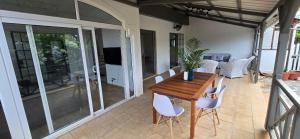 Un comedor con una mesa de madera y sillas blancas. en Maison de Vacances Pereybere, en Grand Baie