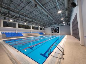 a large swimming pool with blue chairs in a building at Arena Hotel Goranboy in Goranboy