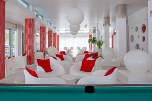 a living room with white chairs and red pillows at Hotel Croce di Malta e Mexico in Cesenatico +41 photos
