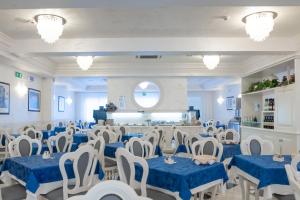 a banquet hall with blue and white tables and chairs at Hotel Croce di Malta e Mexico in Cesenatico