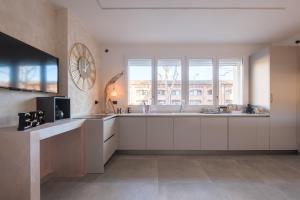 a kitchen with white cabinets and a large window at Malvasiasuites in Bologna