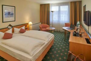a hotel room with a bed and a desk at Balance Hotel Leipzig Alte Messe in Leipzig