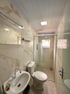 a bathroom with a toilet and a sink and a shower at Loft e Suites Temporada in Balneário Camboriú +28 photos