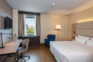 Cama ou camas em um quarto em NH Geneva Airport Hotel