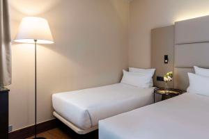 Cama ou camas em um quarto em NH Geneva Airport Hotel