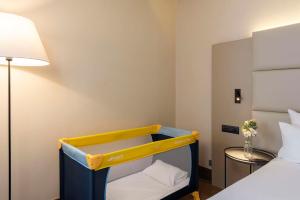 Cama ou camas em um quarto em NH Geneva Airport Hotel