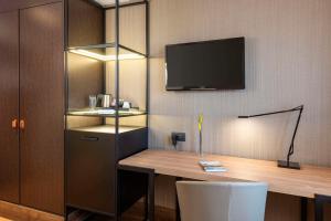 Uma TV ou centro de entretenimento em NH Geneva Airport Hotel